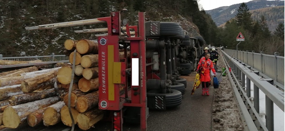 Un autoarticolato si rovescia lungo la strada e perde i tronchi di legno